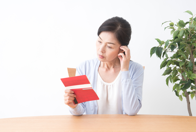 通帳を眺める女性