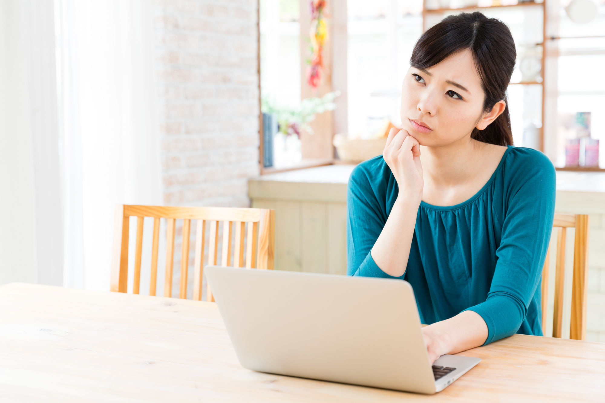 住宅でPCと悩む女性